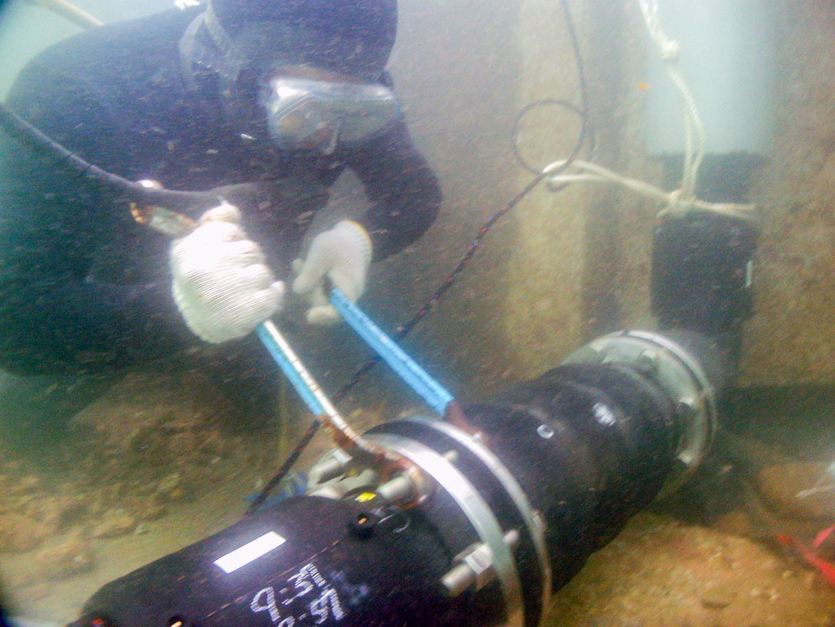 フランジのボルトを、潜水士の手作業により締めています。